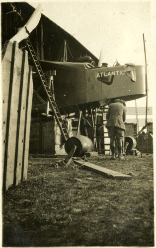 Cockpit of the aircraft, with the name Atlanticf visible, in a makeshift hangar.