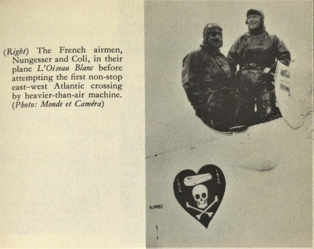 Two aviators standing in the cockpit of an aircraft. The aircraft has an image of a black heart with a skull and crossbones and a coffin.
Book caption reads: The French airmen, Nungesser and Coli, in their plane L'Oiseau Blanc before attempting the first non-stop east-west Atlantic crossing by heavier-than-air machine.