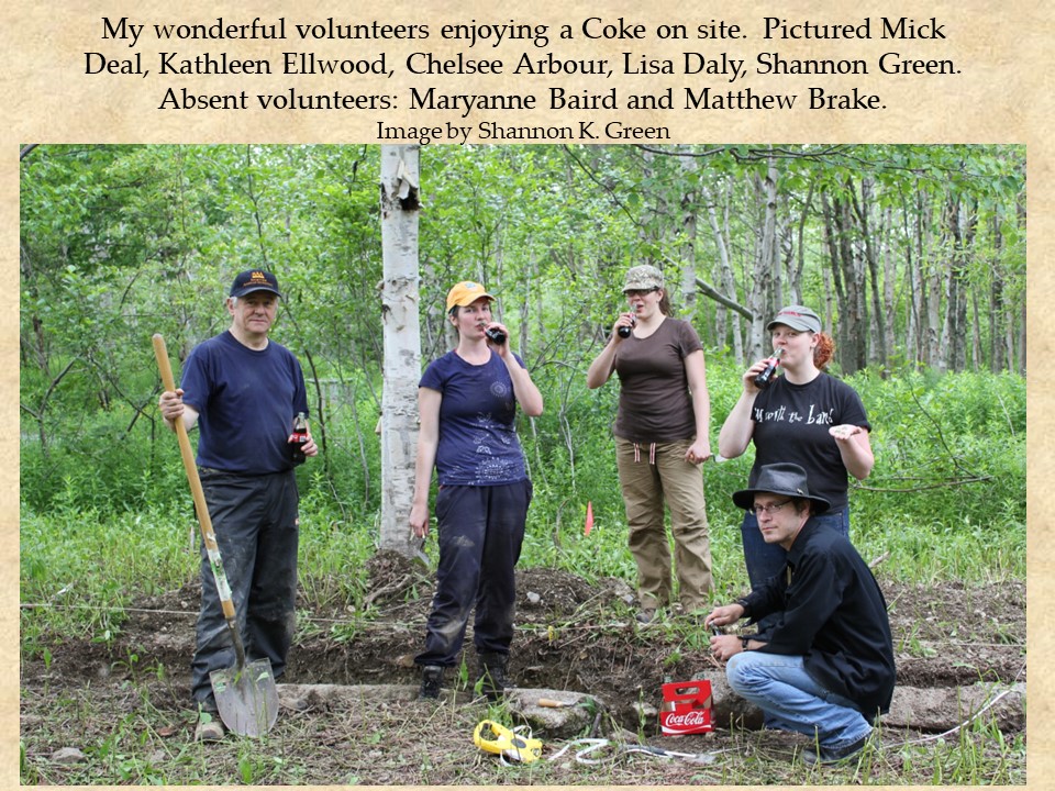A field crew image where everyone is holding fragments of Coke bottles found on site while drinking from contemporary bottles.